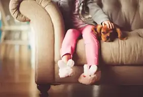 Child and dog sitting on clean couch