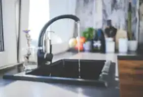 Water running in a modern kitchen faucet